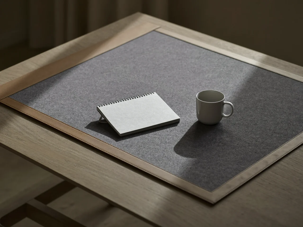 Große Filz-Leder-Unterlage auf Eichenschreibtisch mit Notizbuch und Keramiktasse, Illustration